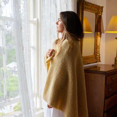 woman standing wearing Eriu's family blanket in Honeybee